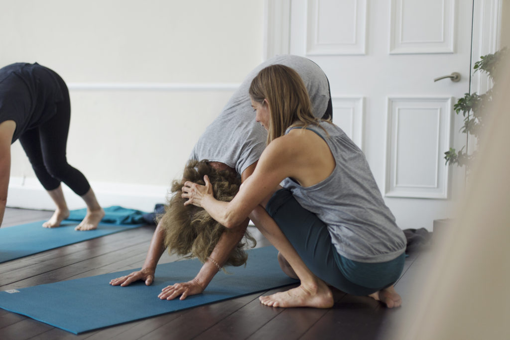 Caroline Reid, Bristol based Scaravelli-inspired yoga teacher, hands-on adjusting in Downward Dog Pose