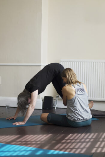 Caroline Reid, Bristol based Scaravelli-inspired yoga teacher, hands-on adjusting in Downward Dog Pose